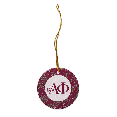 Alpha Phi Holiday Ornament shown with gold hanging cord and Alpha Phi logo and floral print