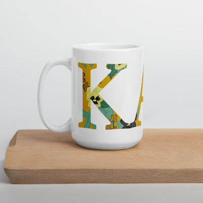Kappa Alpha Theta Floral Filled Letters White Glossy Mug in 15 oz size on wood shelf