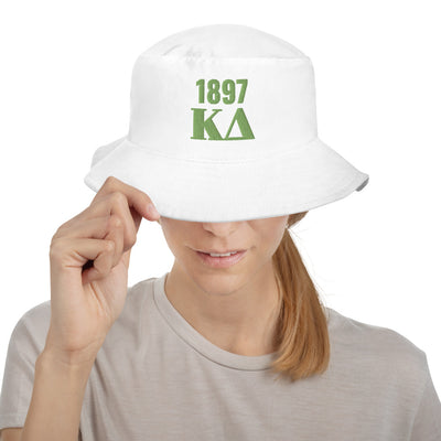 Model wearing a white bucket hat with green Kappa Delta and 1897 embroidered