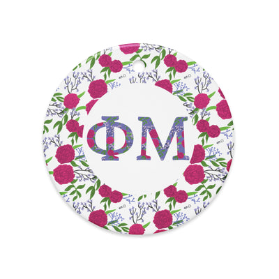 Phi Mu Ceramic Ornament shown in close up view with filled Phi Mu letters and floral trim