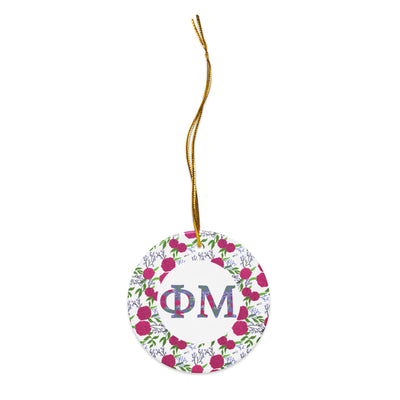 Phi Mu Ceramic Ornament shown in close up view with filled Phi Mu letters and floral trim shown with gold hanging thread