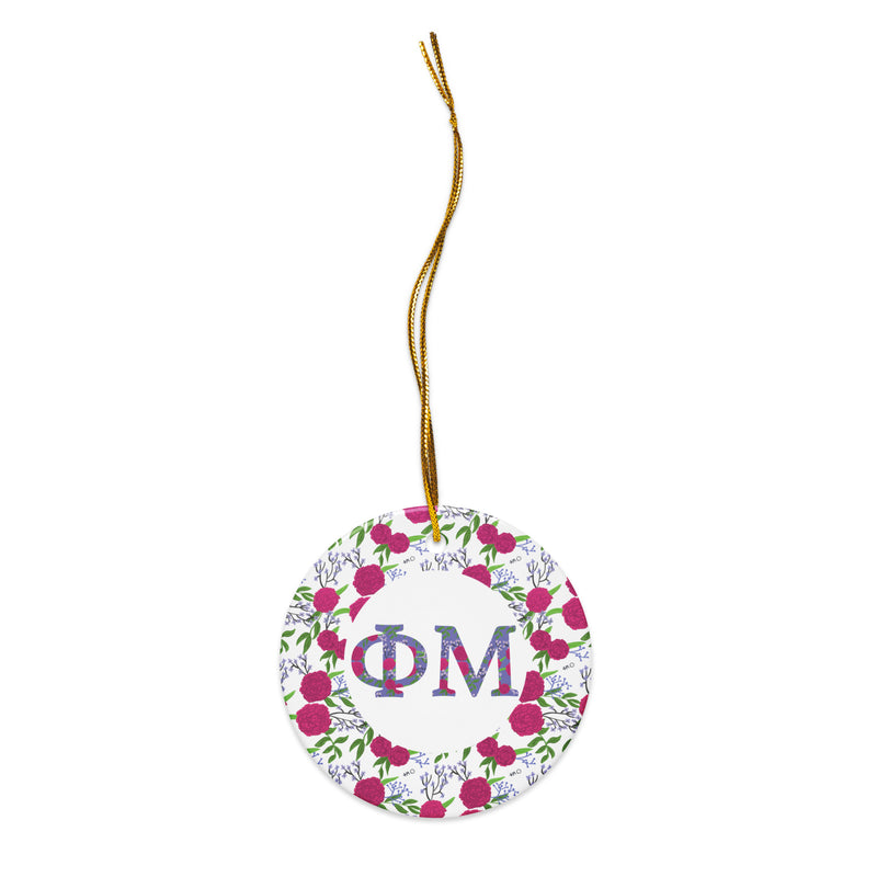 Phi Mu Ceramic Ornament shown in close up view with filled Phi Mu letters and floral trim shown with gold hanging thread
