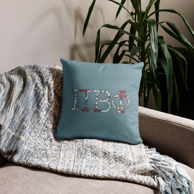 Pi Beta Phi Letters Reversible Pillow shown on a couch in silvery blue in 18" x 18" size