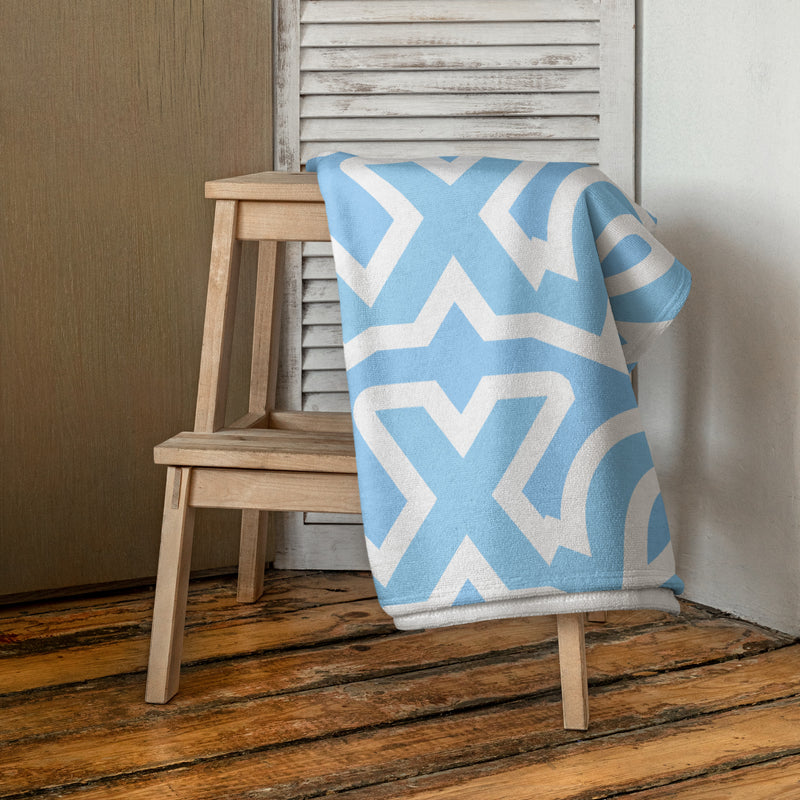 Alpha Chi Omega Beach and Bath Towel shown draped over wooden stool