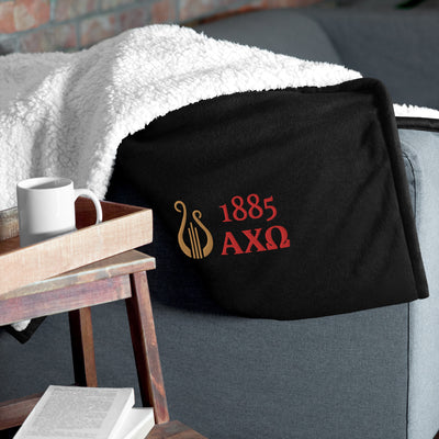 Alpha Chi Omega Plush Embroidered Sherpa Blanket in black in living room