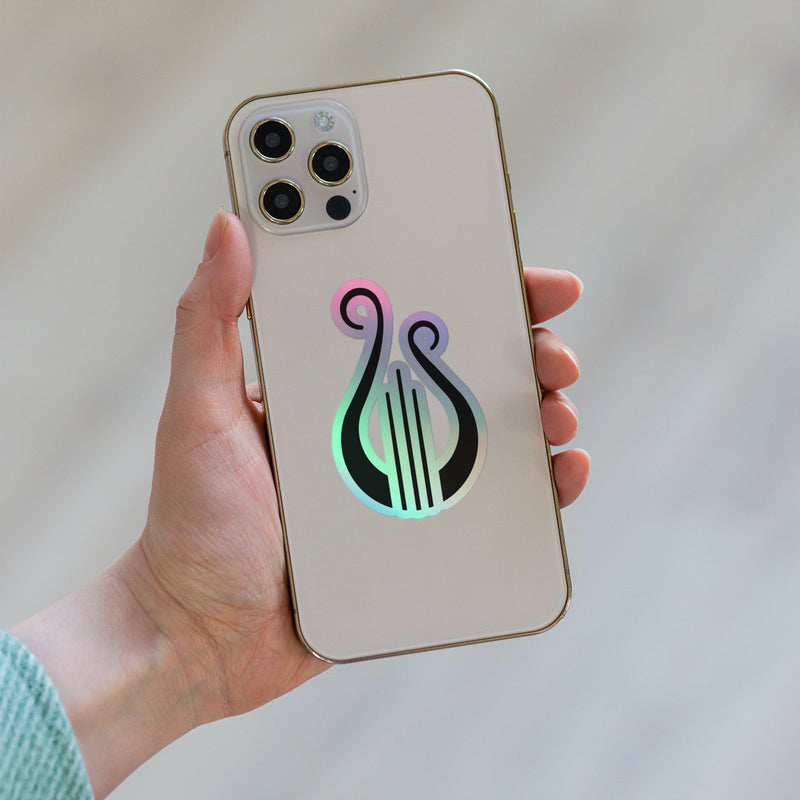 Our Alpha Chi Omega Lyre Holographic Sticker shown on phone.