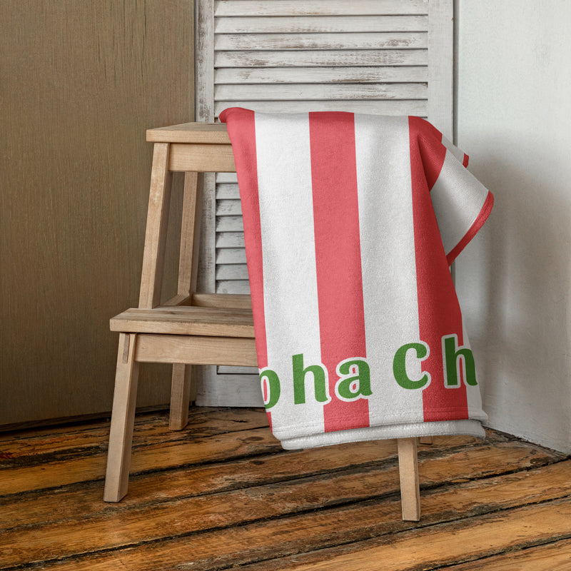 Alpha Chi Striped Cabana Towel shown draped over wood stool