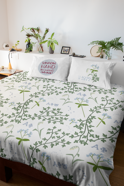 alpha phi floral print duvet cover in white shown on bed with pillows