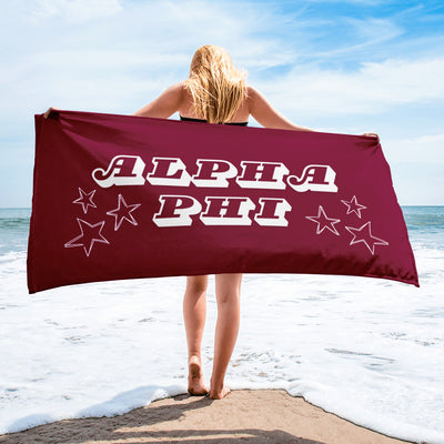 Alpha Phi Starry Beach Towel in burgundy on model at beach