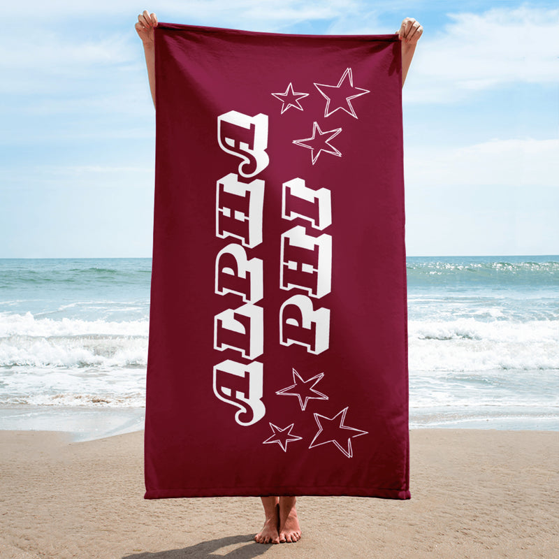 Alpha Phi Starry Beach Towel held up by model at beach with starry design