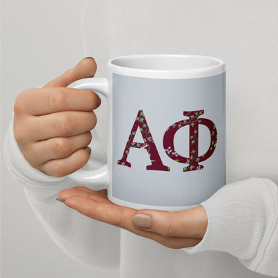 Alpha Phi Sorority Mug with filled letters in silver and Bordeaux in model's hands in 20 oz size