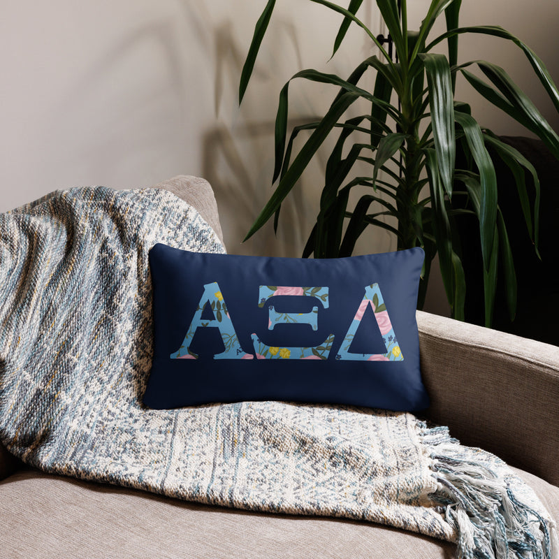 Alpha Xi Delta Sorority Pillow on couch showing Alpha Xi letters filled with floral print in 20" x 12" size