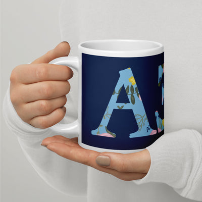 Alpha Xi Delta Sorority Mug in 20 oz size with letters filled with floral print in Navy Blue in model's hands