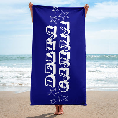 Delta Gamma Sorority Beach Towel in full view being held up lengthwise on a beach