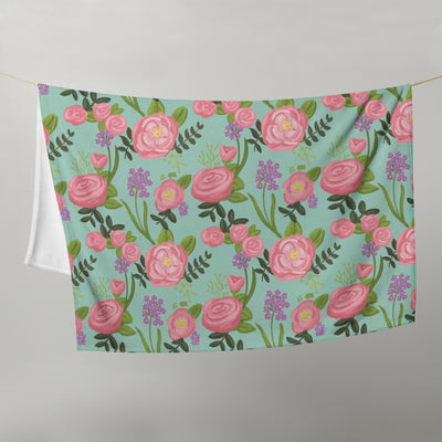 Delta Zeta Sorority Throw Blanket shown hanging on clothesline in green floral print