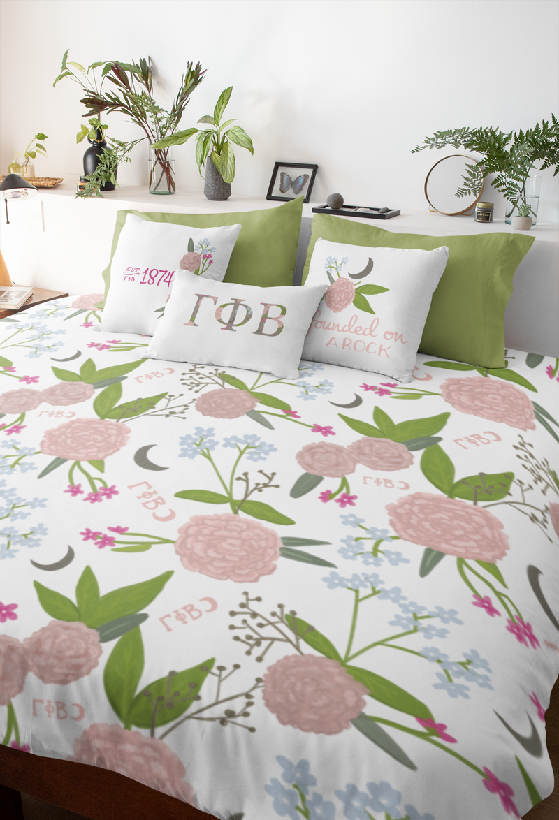 Gamma Phi Beta bedding bundle with carnation and crescent duvet cover and 3 G Phi pillows shown on bed