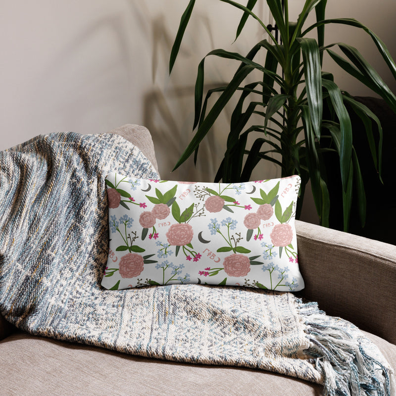 Gamma Phi Beta Filled Letters Pillow showing floral print on back in white on 20" x 12" size shown on couch