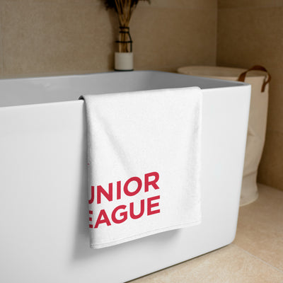 Junior League Beach and Bath Towel in white shown folded over bathtub