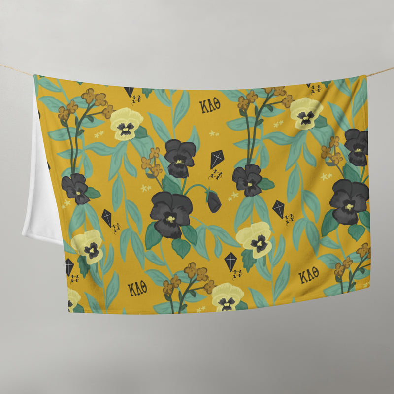 Kappa Alpha Theta Pansy Floral Print Sorority Blanket shown in gold on clothesline