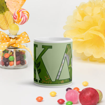 Kappa Delta Letters Mug in light green shown with colorful lifestyle setting