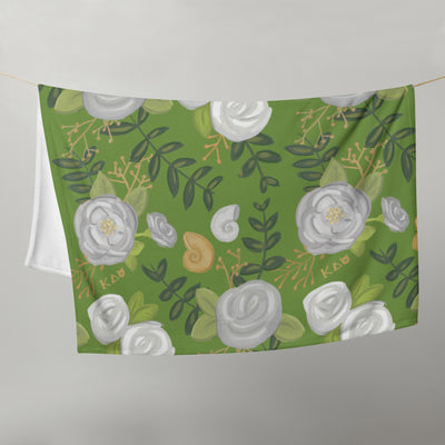 Kappa Delta Floral Print Throw Blanket in green shown hanging on clothesline