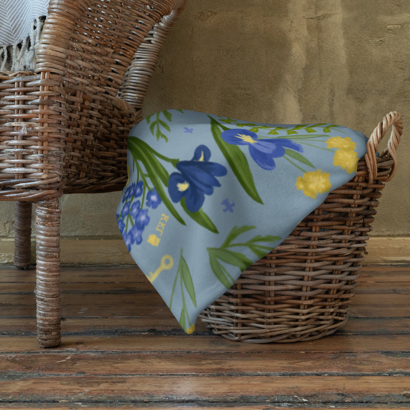 Kappa Kappa Gamma Sorority Throw Blanket shown in folded in basket on floor