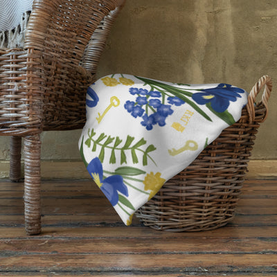 Kappa Kappa Gamma Fleur de Key White Throw Blanket shown stored in basket on floor 