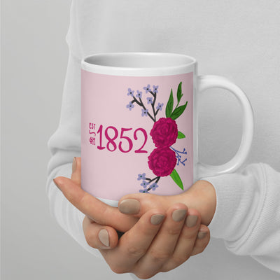 Phi Mu 1852 mug in 20 oz size shown in model's hands 