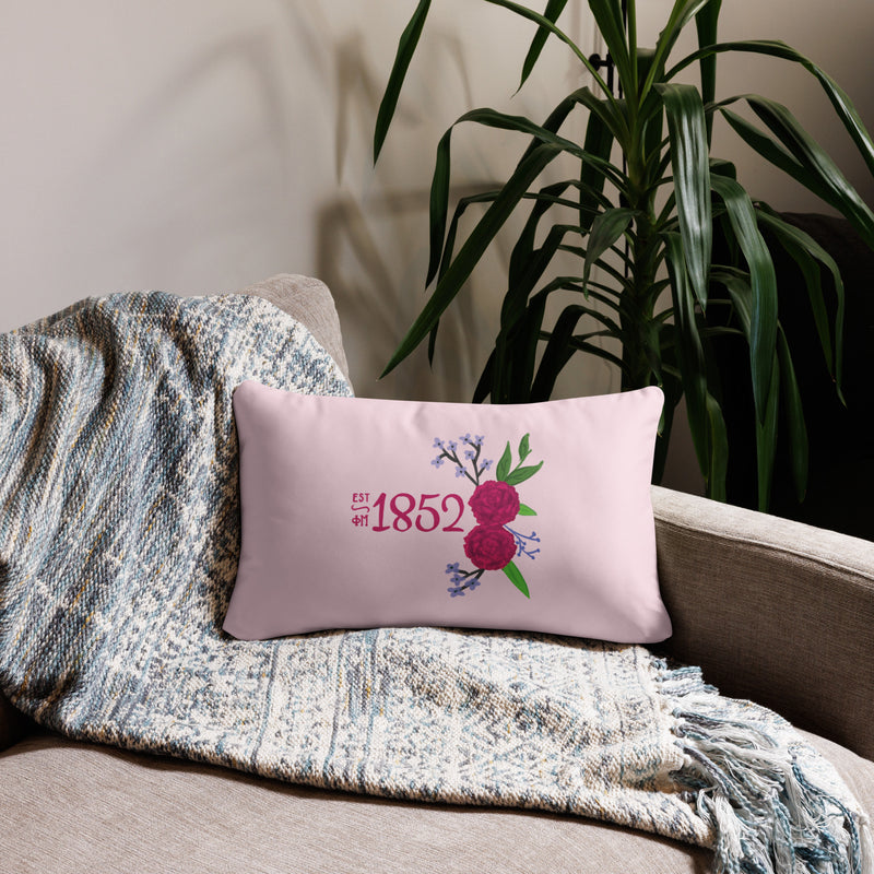 Phi Mu 1852 Reversible Pillow featuring hand drawn 1852 design in pink shown in 20" x 12" lumbar pillow size on couch