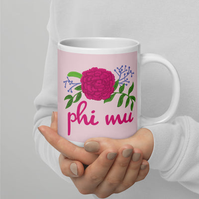 Phi Mu Rose Carnation Sorority Mug shown in 20 oz size in model's hands with handle on right