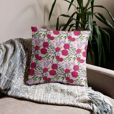Phi Mu motto reversible pillow showing carnation floral print on back of 22" x 22" pillow in light pink shown on couch