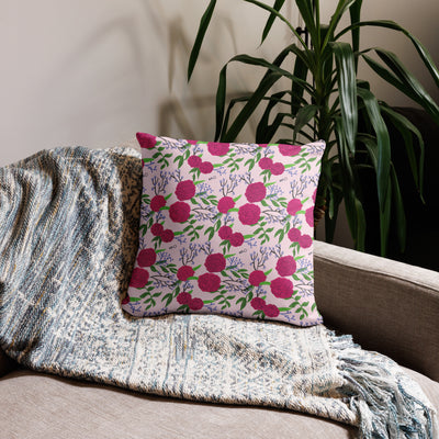 Phi Mu motto reversible pillow showing carnation floral print on back in light pink shown on couch