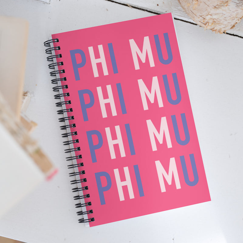 Phi Mu spiral notebook in pink with fun Phi Mu repeat pattern in brand colors