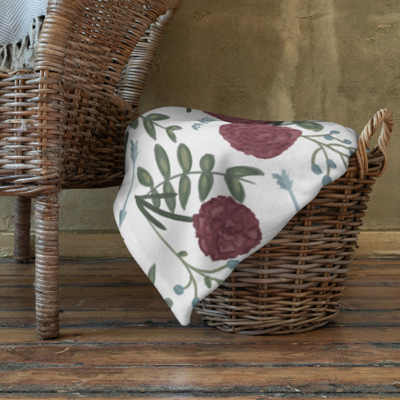 Pi Beta Phi floral throw blanket in white shown folded in basket