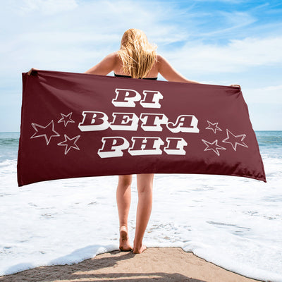 Pi Beta Phi Starry Beach Towel in wine shown with model in beach scene