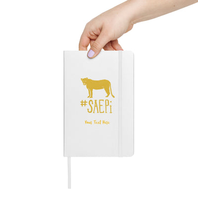 SAEPi Lioness mascot Hardcover Journal in white shown in model's hand