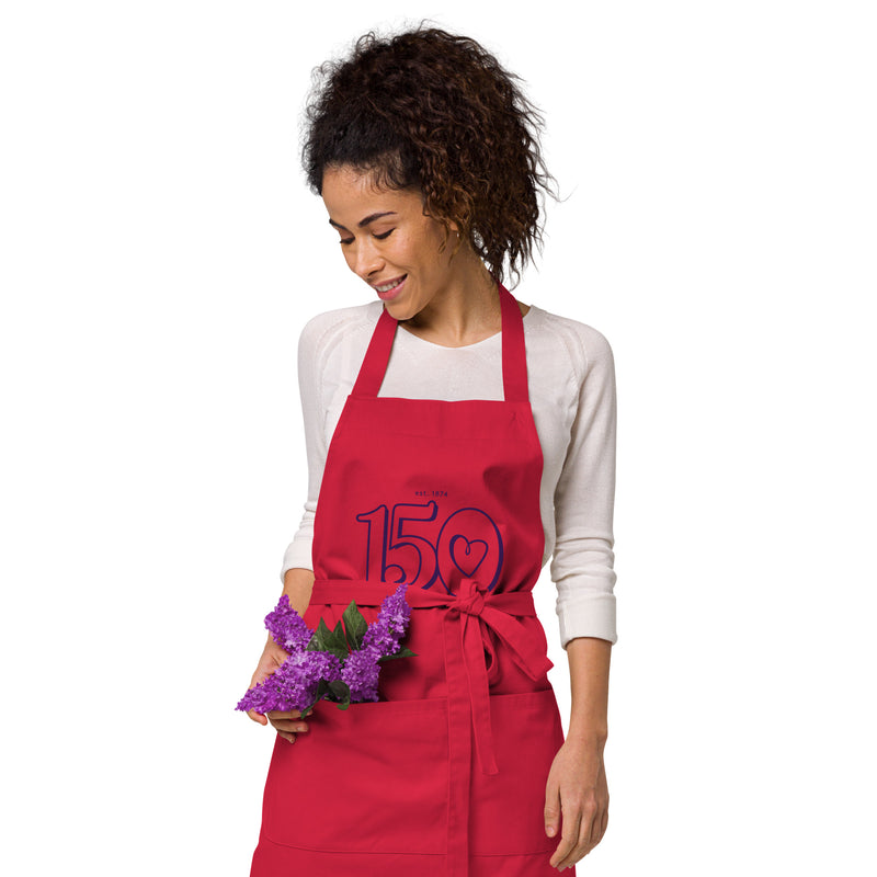 Sig Kap 150th Anniversary Organic Cotton Apron on model in red