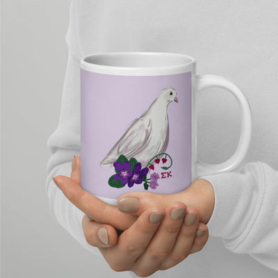 Sigma Kappa Dove Mascot Mug in 20 oz size in lavender showing hand-drawn design in model's hands