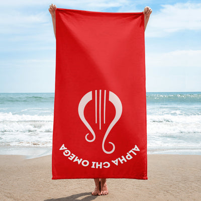 Alpha Chi Omega Lyre Beach Towel held up by model at beach