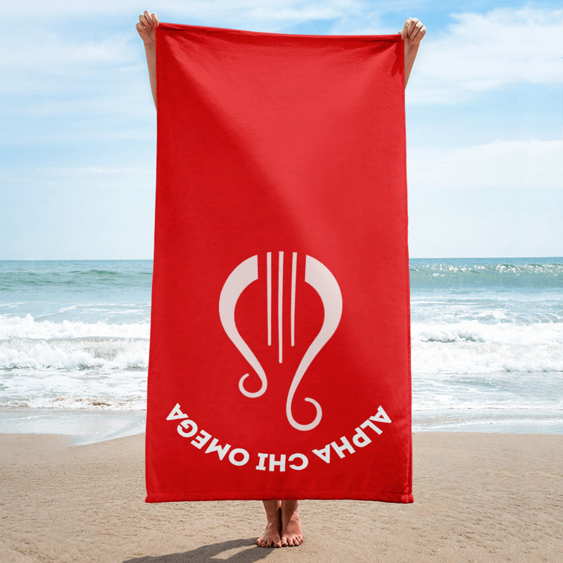 Alpha Chi Omega Lyre Beach Towel held up by model at beach