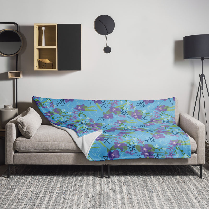 Alpha Delta Pi Violet Floral Azure Blue Blanket shown on couch