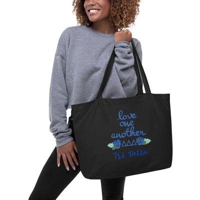 Tri Delta Sorority Tote Bag featuring Tri Delt motto and letters on black tote bag on model's arm