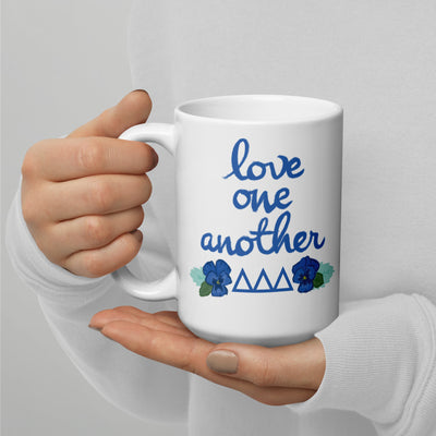 Tri Delta Mom mug with filled letter and motto design on each side in 15 oz size shown in model's hands