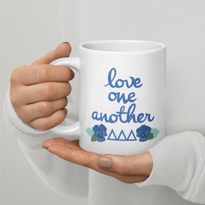 Tri Delta Mom Mug with motto and filled letter design in 20 oz size shown in model's hands