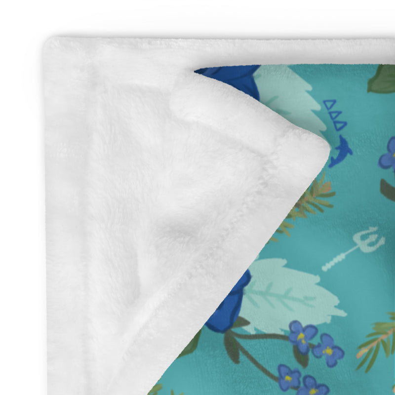 Tri Delta Pansy Floral Print Teal Throw Blanket showing solid white reverse side