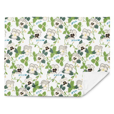 Zeta Tau Alpha Violet Print Blanket shown in full view showing letters and sorority flower and solid white reverse side