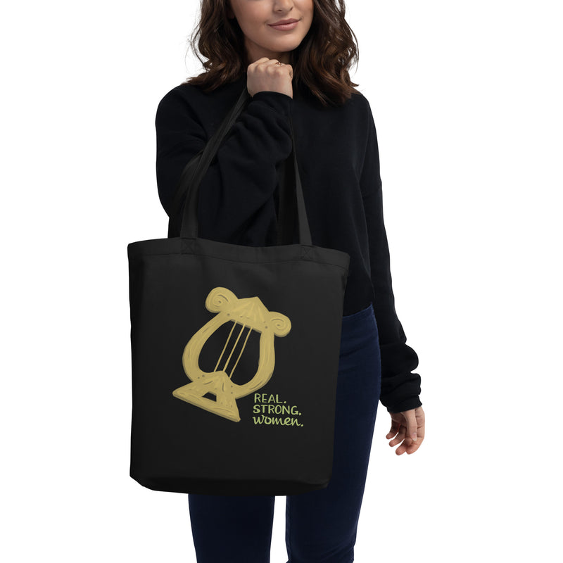 Alpha Chi Omega Real. Strong. Women Eco Tote Bag in black shown on woman&