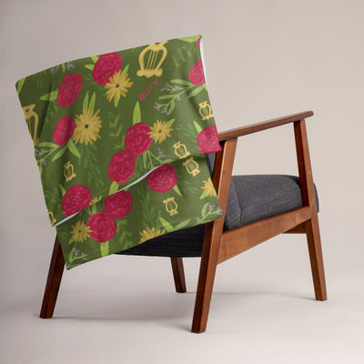 Our soft and warm Alpha Chi Omega Carnation Floral Print Throw Blanket in Olive Green in a lifestyle setting.