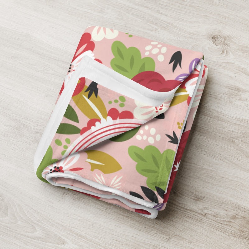 Our Alpha Chi Omega floral print throw blanket in Hera Pink shown tightly folded. 