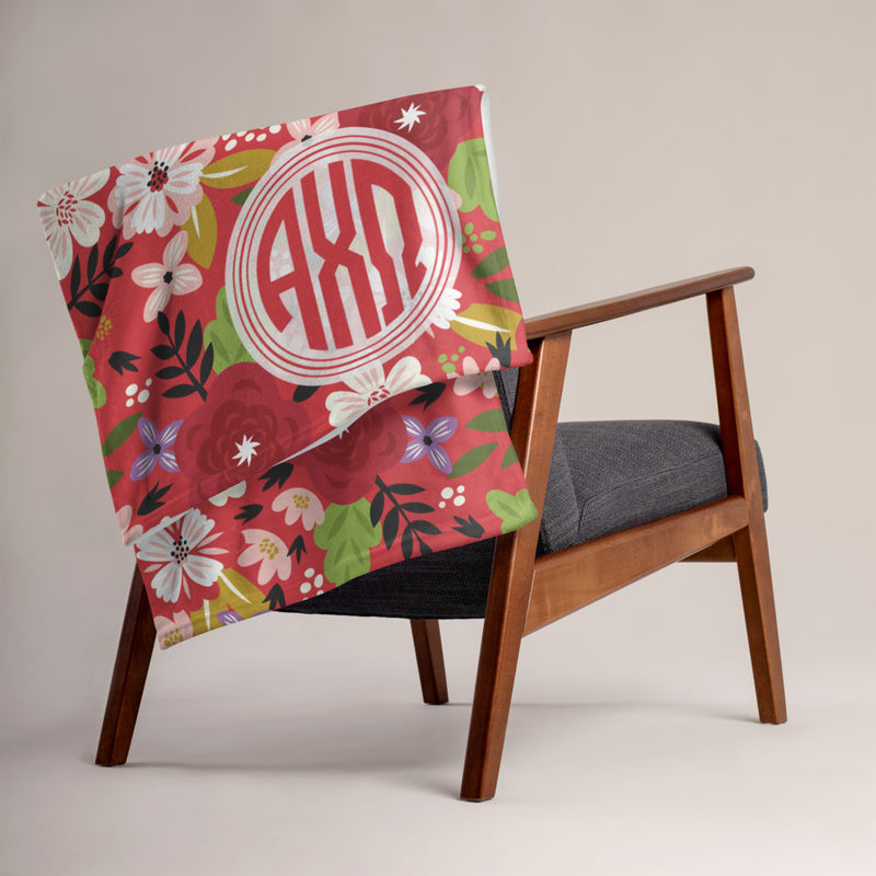 Alpha Chi Omega throw blanket in Scarlet Red shown over a chair.